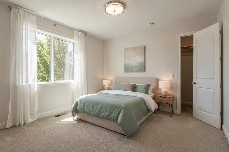 Primary bedroom with large window and walk-in closet